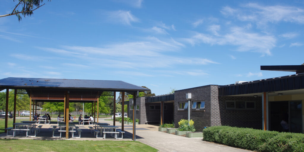 Students under shaded cover outside Year 9 building